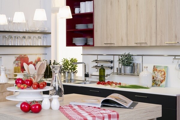 Küche im Hygge-Stil, zum Beispiel so: mit mehreren schönen Hängelampen, die weiche Spots auf die besucherfreundliche Kücheninsel werfen